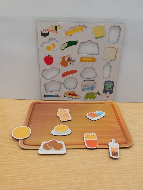 《控糖特攻隊》附有磁石餐盤，加上各種美食磁石，讓小朋友體驗如何精明選擇三餐，更可配合美食遊戲卡來玩。