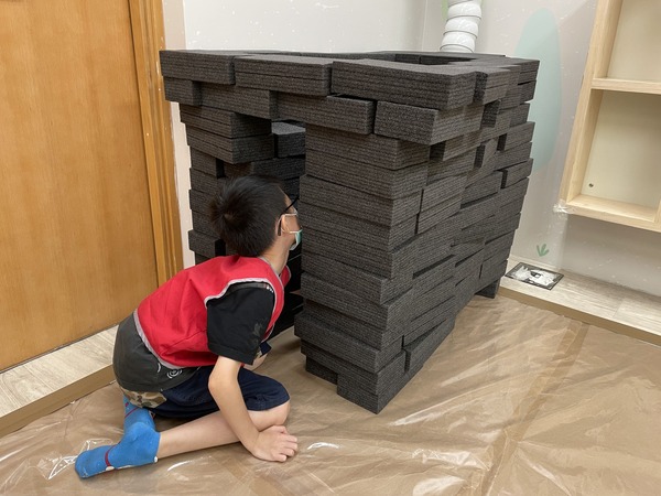 小朋友以特備珍珠棉黑磚，堆疊拼砌一個只限動物進入的城堡。