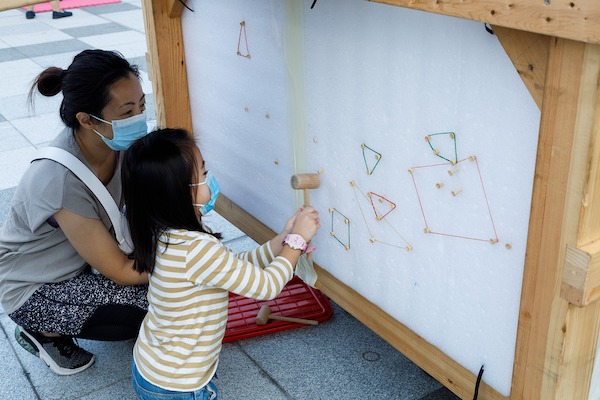 攀爬木台下特設不同的遊戲角落，小朋友可透過木鎚、木釘和彩色橡筋，建構各種圖案。