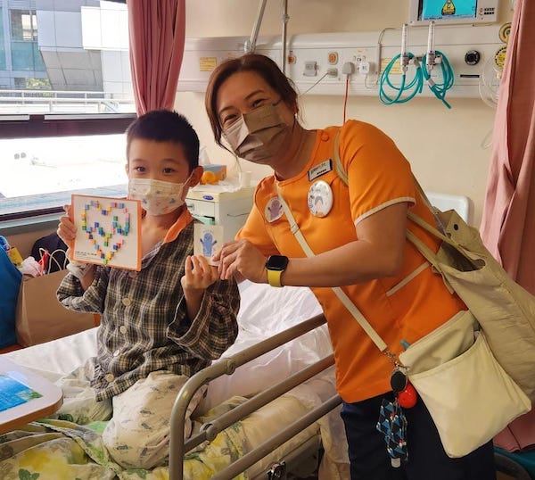 病房的小朋友對醫院遊戲師送上的節日限定遊戲包，大表高興，少不了與醫院遊戲師來張合照。