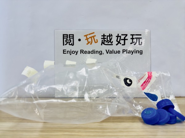 以密實袋製成繪本主角口水龍阿丹，可隨意畫上恐龍五官和貼上背鰭，當充氣後更可發出「啪啪」的吼叫聲；放上象徵口水的樽蓋再拍打，就可玩張口時噴發樽蓋，令人措手不及。