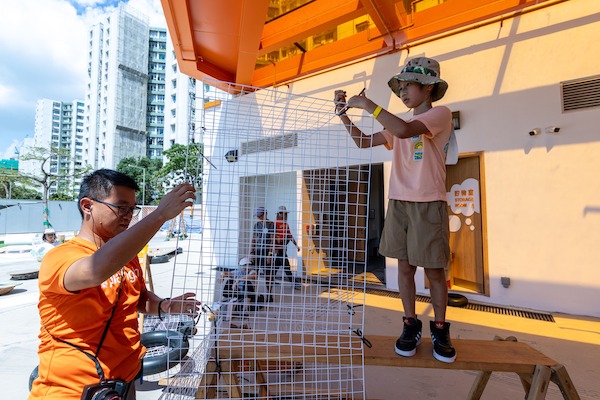 在遊戲工作員的支援下，小朋友嘗試在半空建造立體網架。