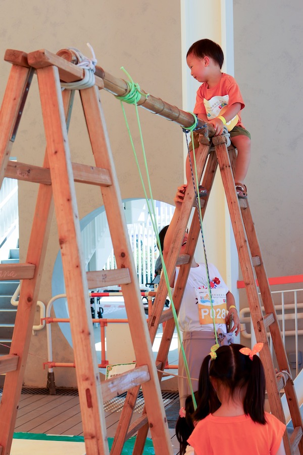 小朋友爬上高高的木梯，親身示範兒童特有的愛挑戰本性。