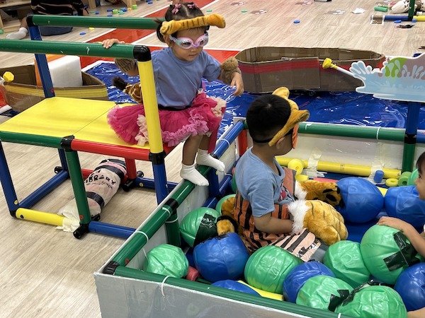 不熟水性的小老虎戴上泳鏡，小心翼翼地跳入水池，與大老虎組隊一起挑戰水球項目。