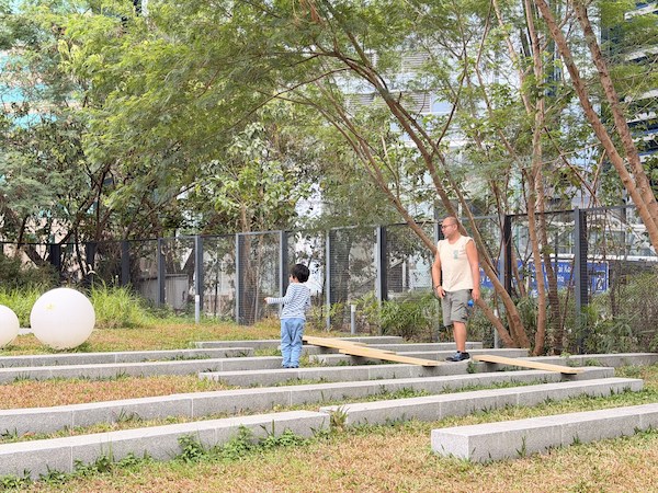 在2025年12月於東區舍區舉行的「好玩社區跨年跨月玩」中，好玩爸爸與小朋友善用場地的梯級設計，加入長度不一的木板，建構了融合環境的步道，同時創造充滿幸福感的親子時光。