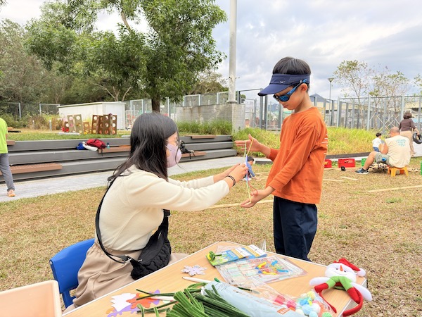 小街坊在現場隨意遊走遊玩，除了製成聖誕樹的裝飾外，更認識了在場的義工，玩起懷舊的翻花繩遊戲來。