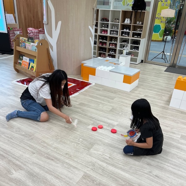 過往工作坊中，家長和小朋友出力搧動迎風的紙碟，把「火」吹向對方。今次目標物轉為輕盈的紙碎，大力搧動之下，更會飛起來，動向將會更難預測。