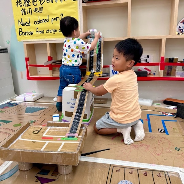 小朋友想像力驚人，把馬路從地面開始，繼而在停車場穿梭，再連接高樓至格子櫃，最最最好玩之處，還可以從高處推動小卡車滑落，體驗高速下滑的爽快和刺激。