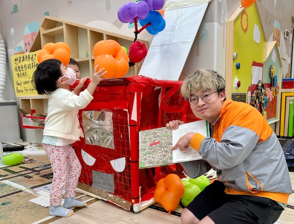 小朋友推著小卡車來帶動花朵氣球的軌跡，花朵飄浮四散，重現了主題繪本的花海一幕。